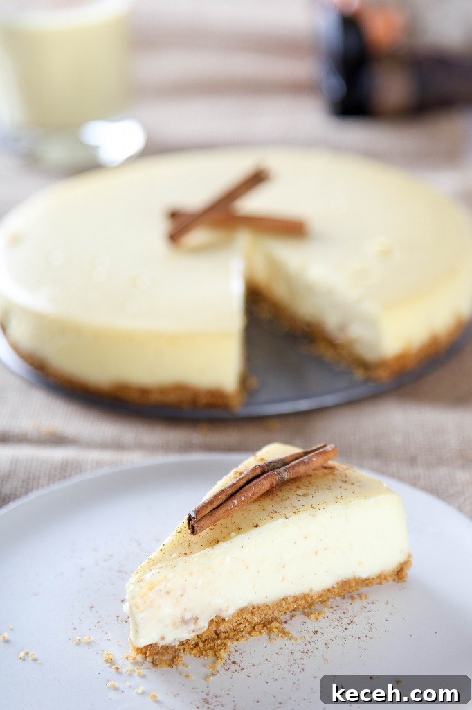 Eggnog Cheesecake Recipe: Creamy Holiday Dessert with Rum Optional 2 a slice of eggnog cheesecake with a graham cracker crust sprinkled with nutmeg and a cinnamon stick.