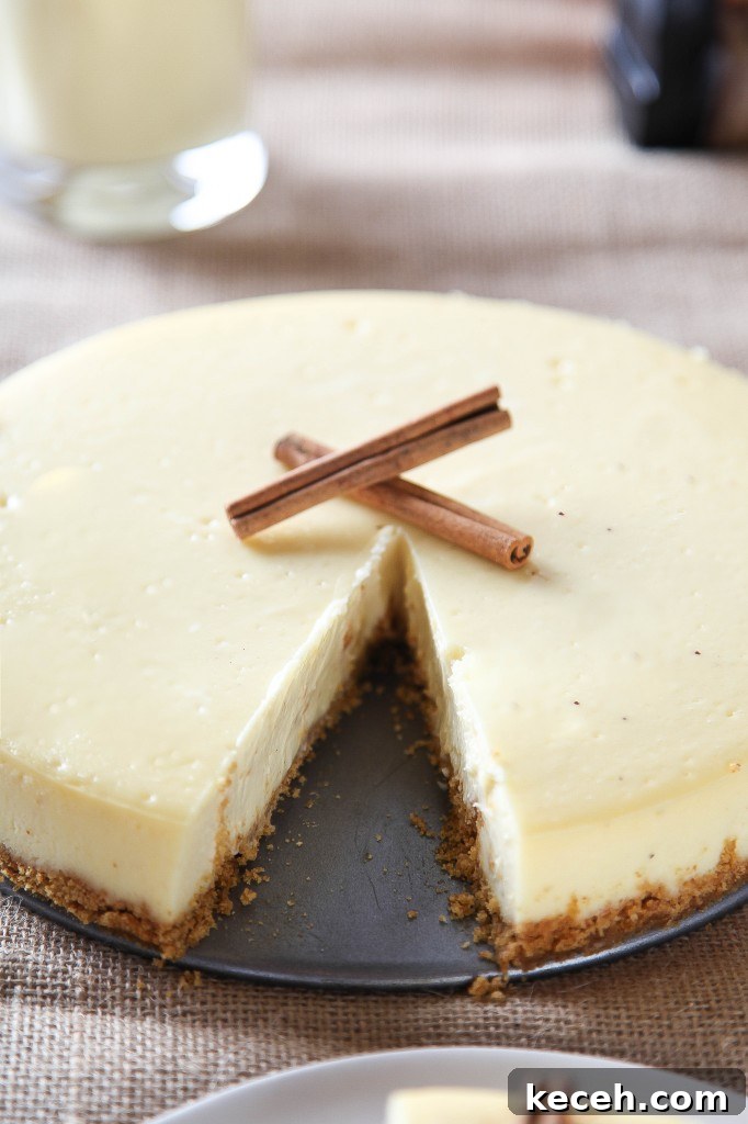 Eggnog Cheesecake Recipe: Creamy Holiday Dessert with Rum Optional 3 an eggnog cheesecake with a graham cracker crust with one slice cut out of it.