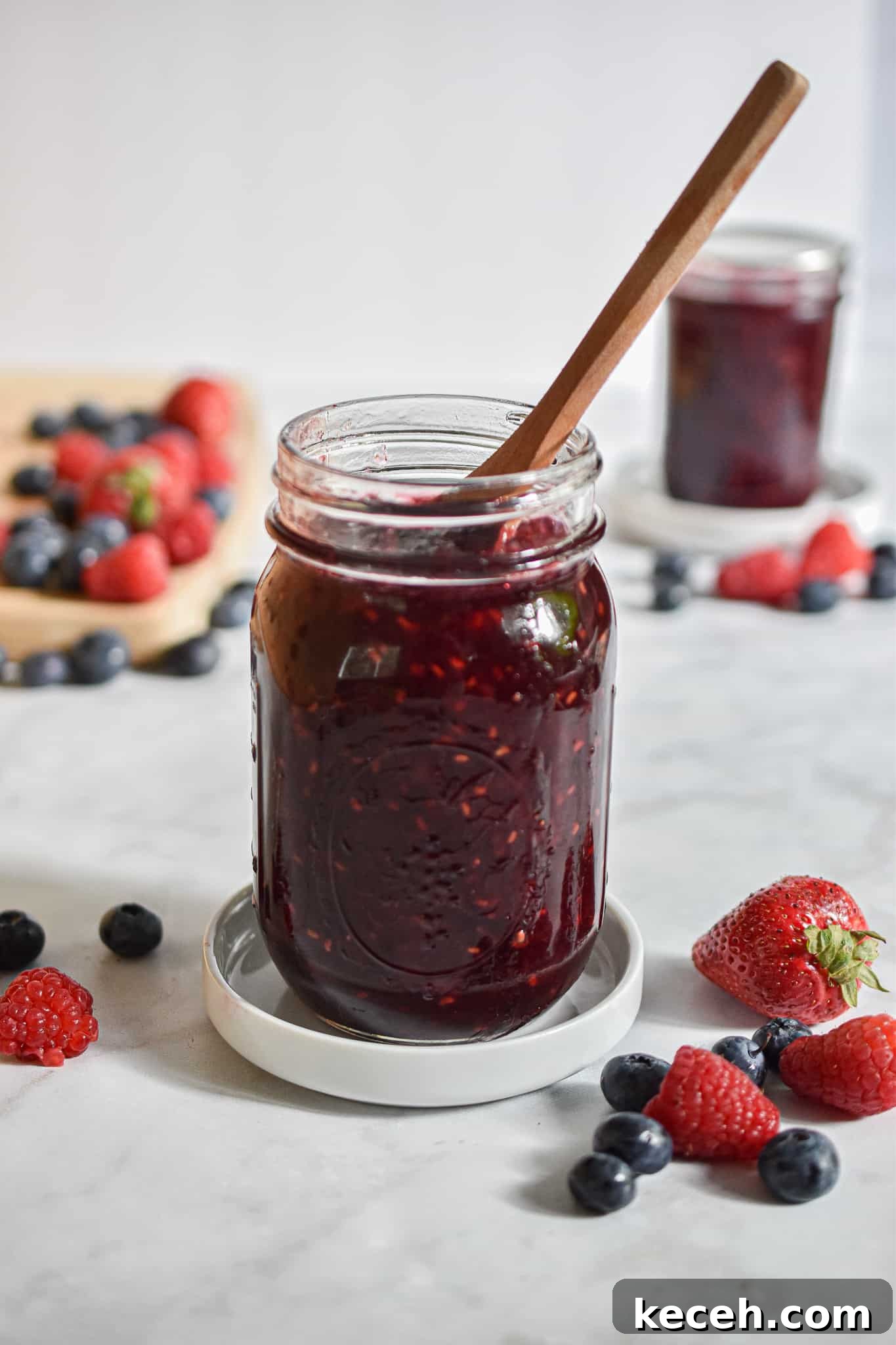 A spoon is in the jar of instant pot mixed berry jam.