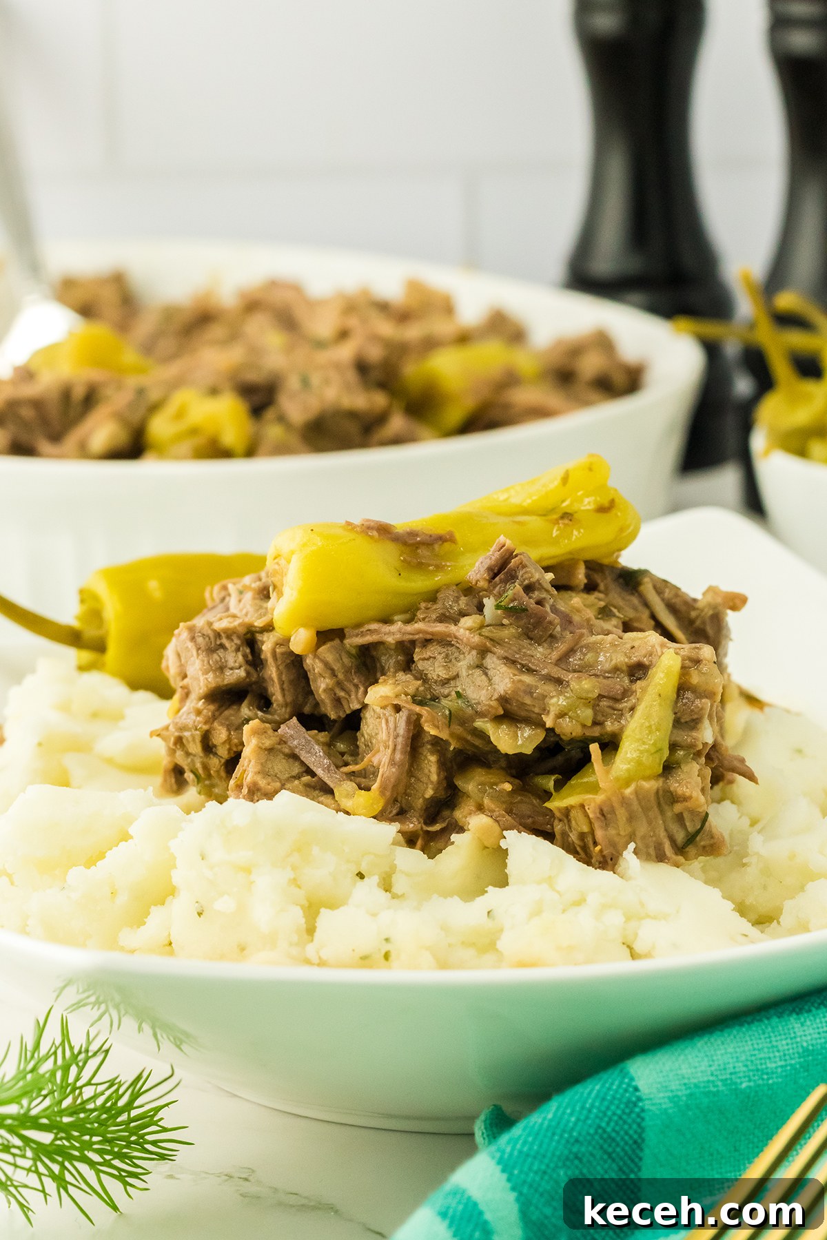 Mississippi Pot Roast in white plate served over mashed potatoes.