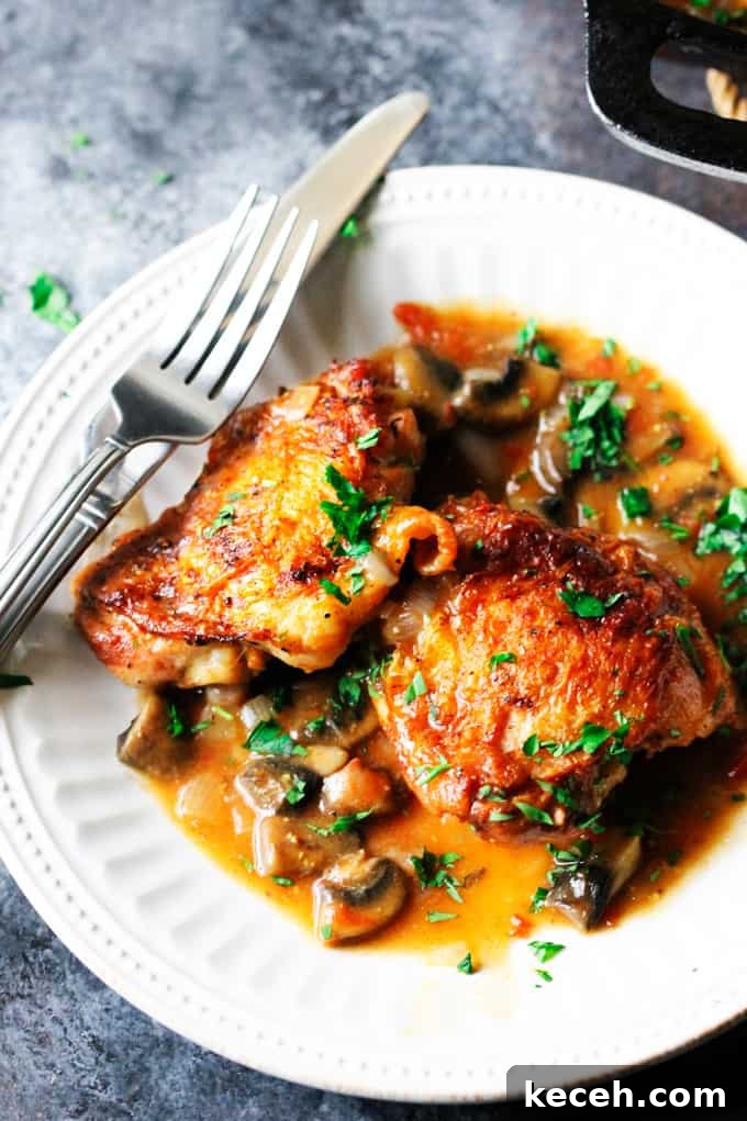 Chicken Chasseur or Hunter's Chicken is one of the most popular French chicken recipes. It contains simple ingredients like bone-in chicken, mushrooms, tomatoes, wine, and herbs. It's very easy to make and looks as amazing as it tastes. Serve it to your guests or family, tell them that it's Chicken Chasseur and you'll impress everybody. But once they've actually sunken their teeth into it, I guarantee they'll be speechless (that happened in my house). How does that sound? French Hunters Chicken on w white plate with fork and knife