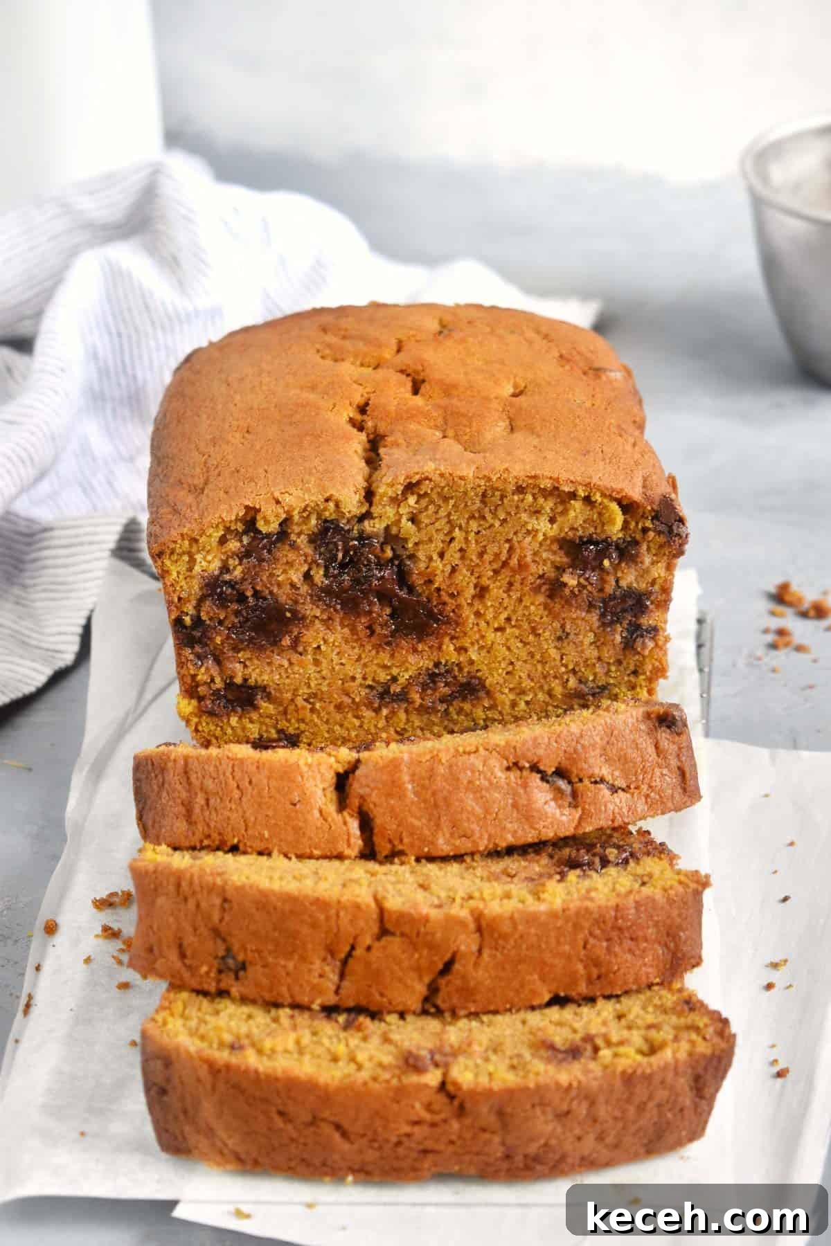 Warm Pumpkin Chocolate Chip Quick Bread: Moist Fall Loaf Recipe 2 sliced pumpkin chocolate chip bread with white dish towel