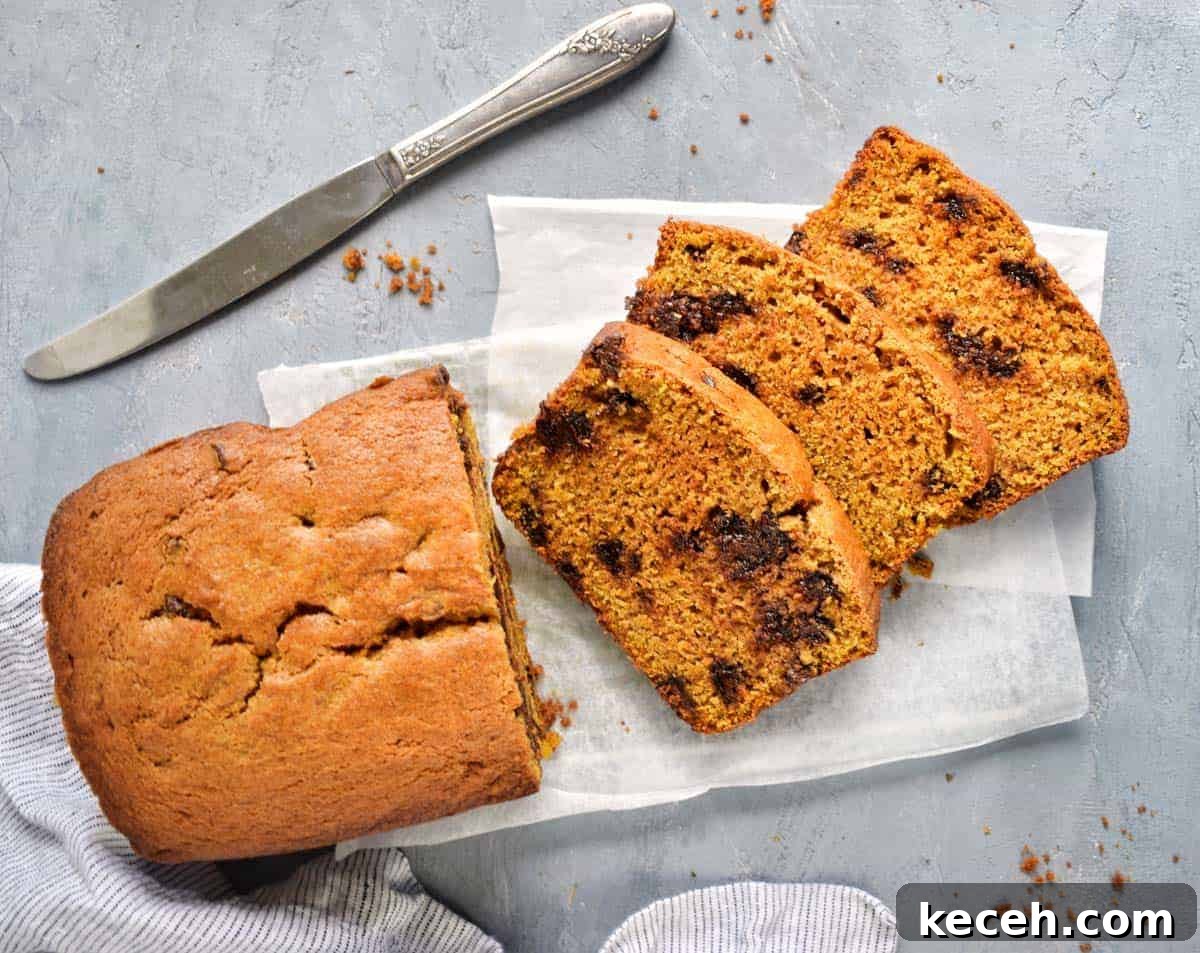 Warm Pumpkin Chocolate Chip Quick Bread: Moist Fall Loaf Recipe 6 A knife with slices of warm pumpkin bread on parchment paper.