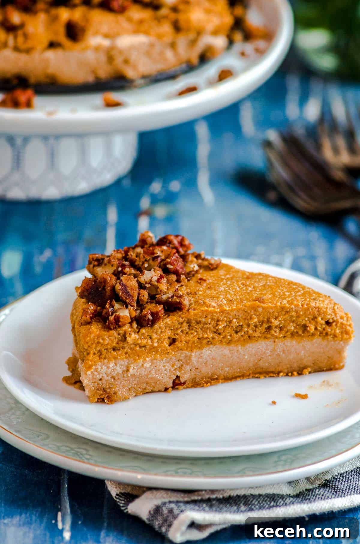 Vegan Pumpkin Cheesecake with Candied Pecans — Holiday Dessert Recipe 12 A slice of vegan cheesecake with pumpkin mousse on a plate