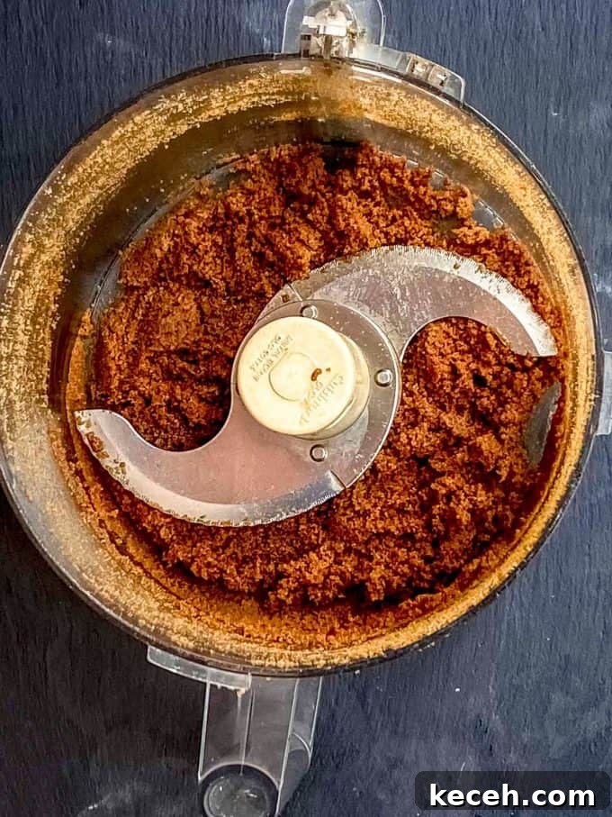 Vegan Pumpkin Cheesecake with Candied Pecans — Holiday Dessert Recipe 4 an overhead view of a food processor with vegan cheesecake crust being mixed