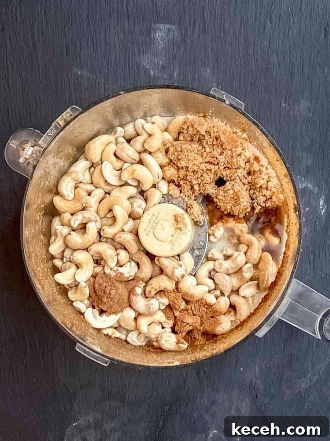 Vegan Pumpkin Cheesecake with Candied Pecans — Holiday Dessert Recipe 7 an overhead view of a food processor with the ingredients to make vegan cheesecake filling