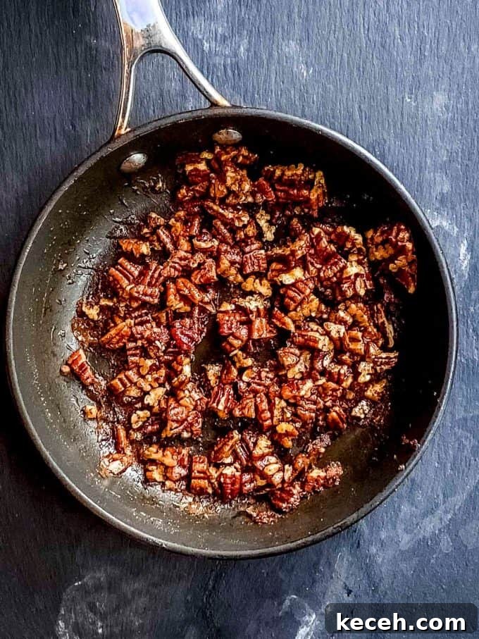 Vegan Pumpkin Cheesecake with Candied Pecans — Holiday Dessert Recipe 10 An overhead view of pecans on a skillet being coated