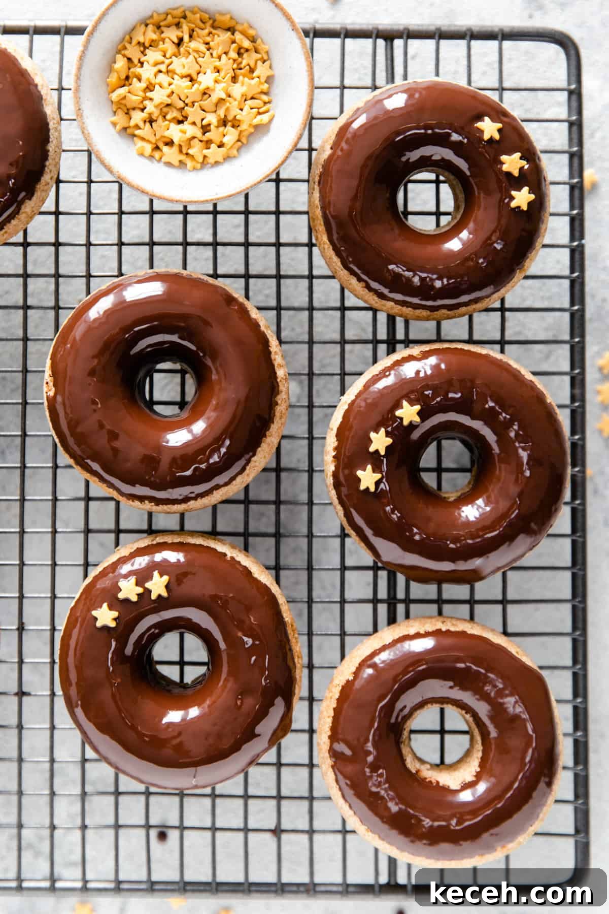Baked Donuts with Rich Chocolate Glaze Recipe 6 overhead shot of baked doughnuts dipped in chocolate glaze decorated with small star-shaped sprinkles