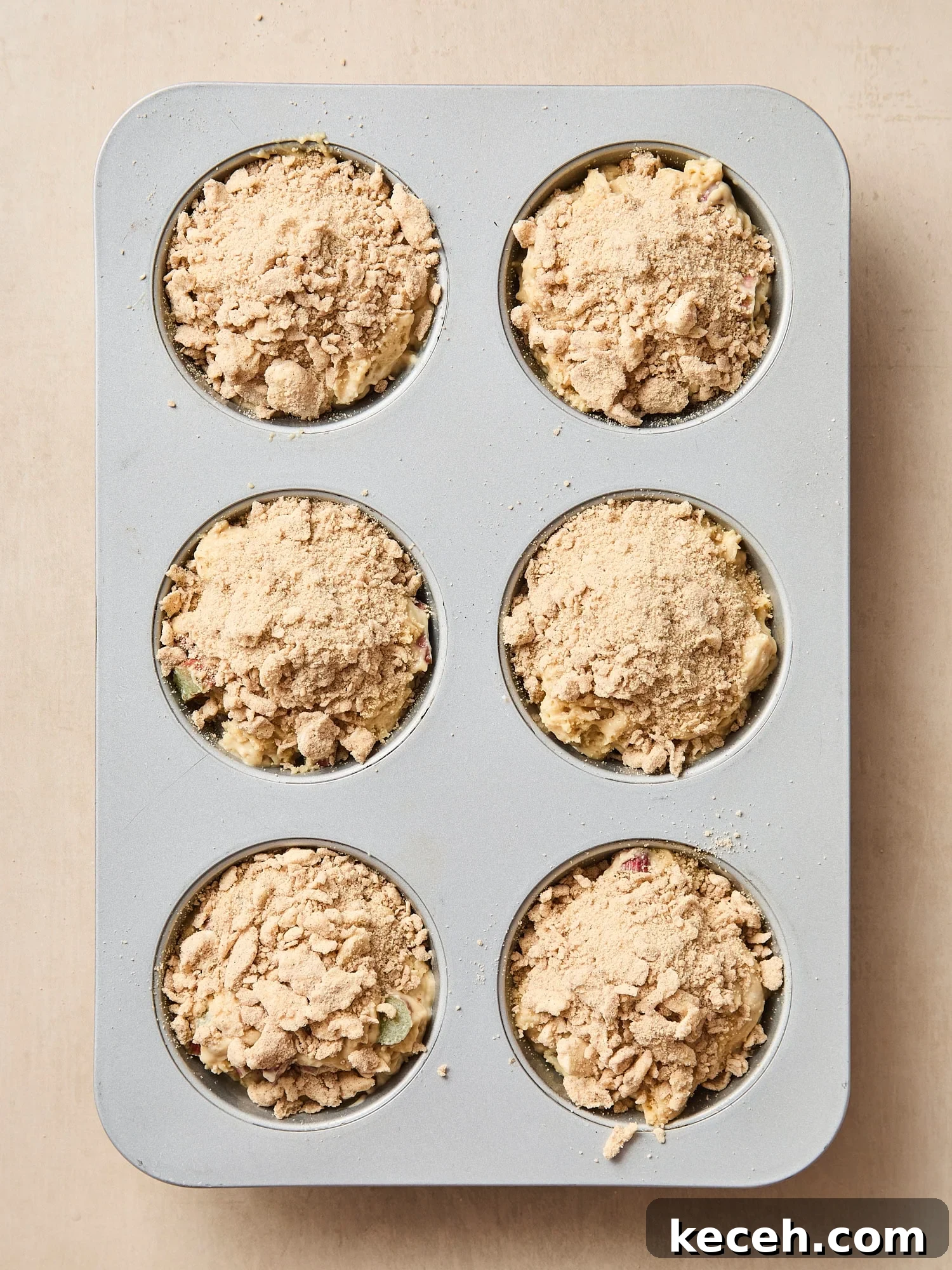 Tangy Rhubarb Muffins with Crunchy Streusel Topping 8 Muffin pan with unbaked muffins with streusel on top.