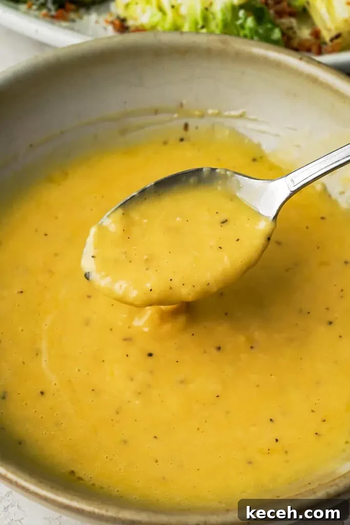 Caesar salad dressing ceasar salad dressing in a bowl with a spoon showing its smooth texture