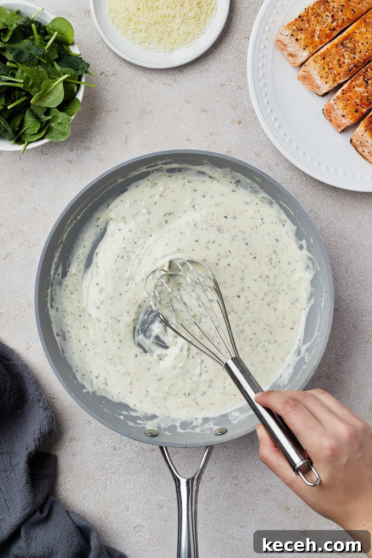 Creamy Spinach Salmon Florentine Recipe for Weeknight Dinners 7 Creamy sauce being whisked in a skillet.