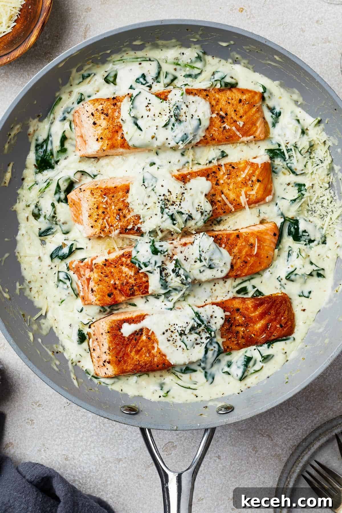 Creamy Spinach Salmon Florentine Recipe for Weeknight Dinners 9 Salmon fillets in creamy spinach sauce in a gray nonstick skillet.