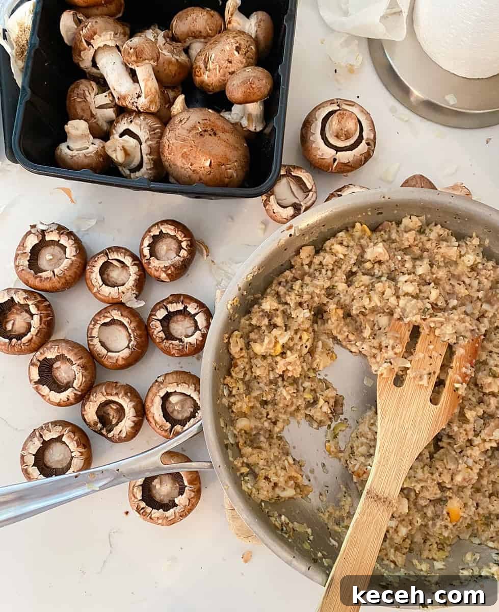 Olive Garden Clam-Stuffed Mushrooms Recipe: Copycat Appetizer 3 Mini bella mushrooms on a table next to italian clam filling in a skillet.