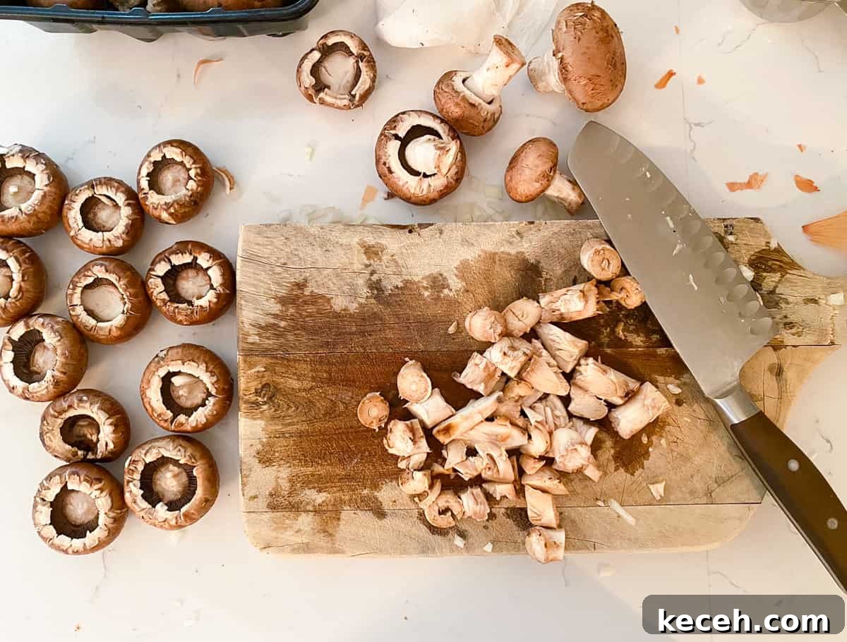 Olive Garden Clam-Stuffed Mushrooms Recipe: Copycat Appetizer 5 Mushrooms on a cutting board with a knife.