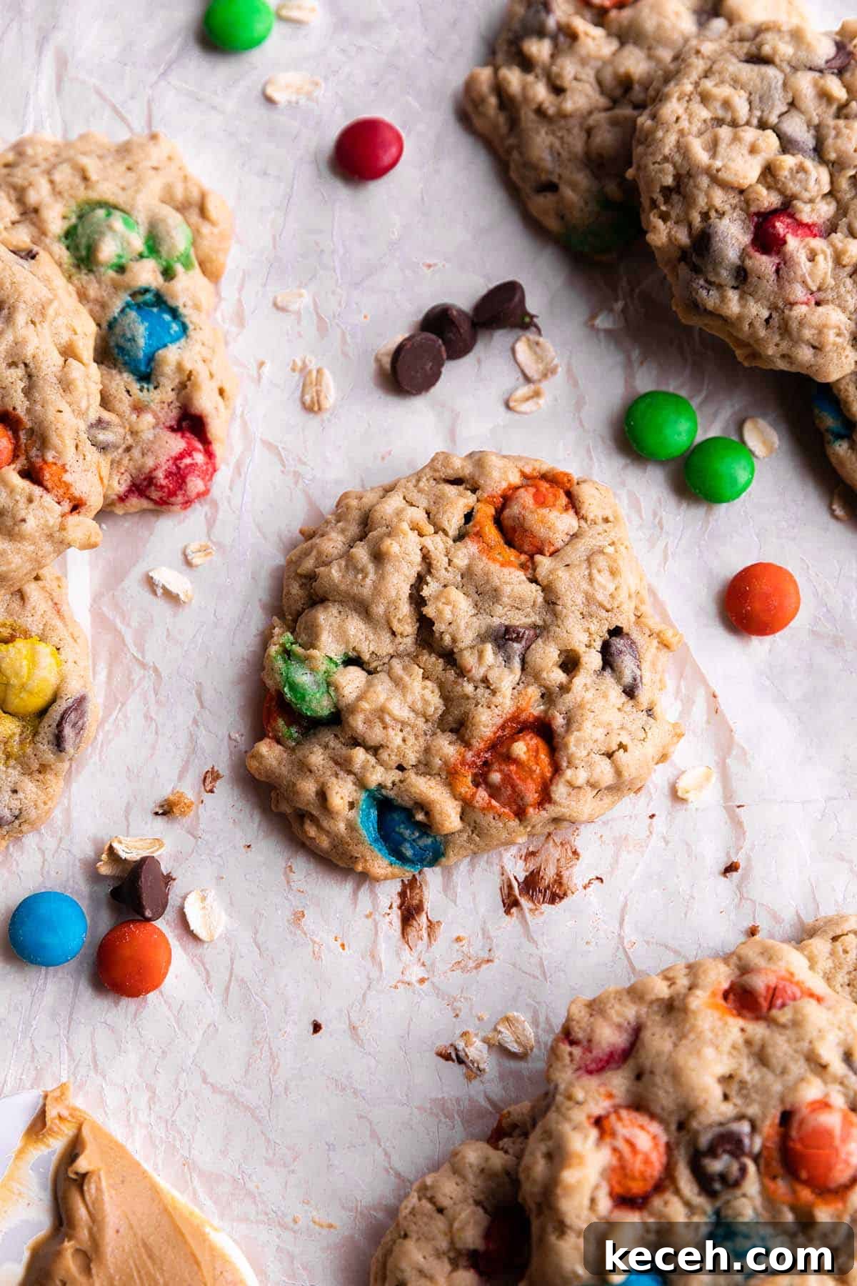 Cookies with oats, m&m's, chocolate chips on parchment paper.