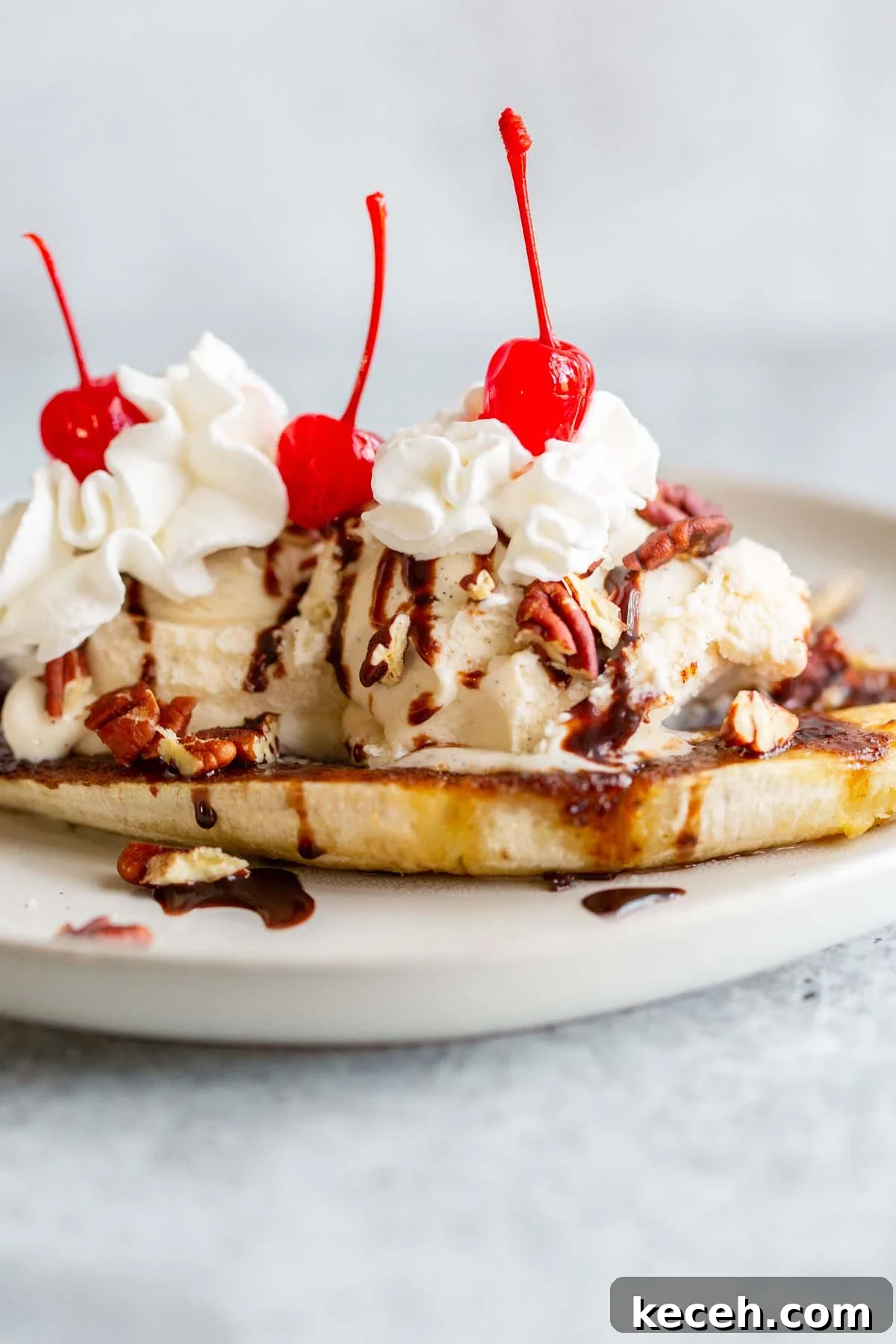 Air Fryer Banana Split Dessert with Warm Caramel and Crisp Toppings 2 Air fryer banana split with whipped cream and cherries.
