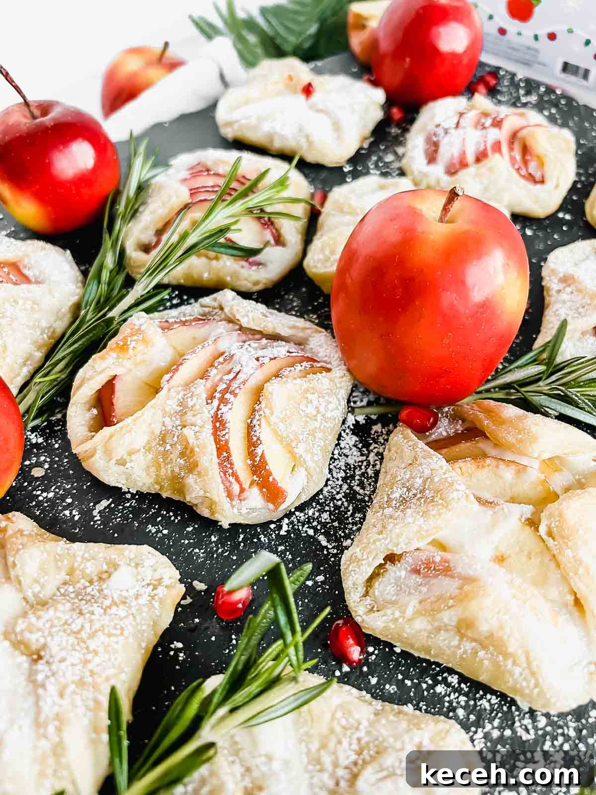 apple cream cheese danishes dusted with powdered sugar arranged on gray serving platter.
