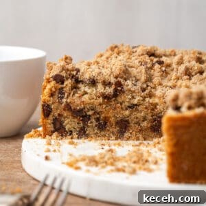 A sliced chocolate chip coffee cake sitting on a white serving dish.