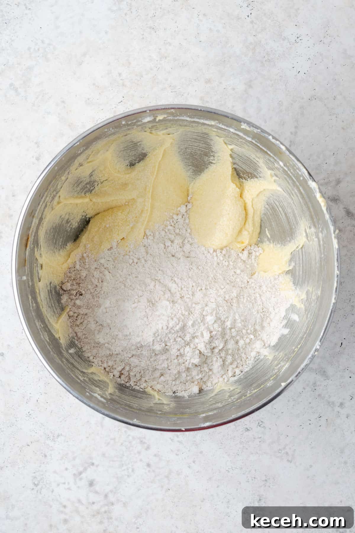 Half of the dry ingredients being added to the bowl with the partially mixed coffee cake batter.