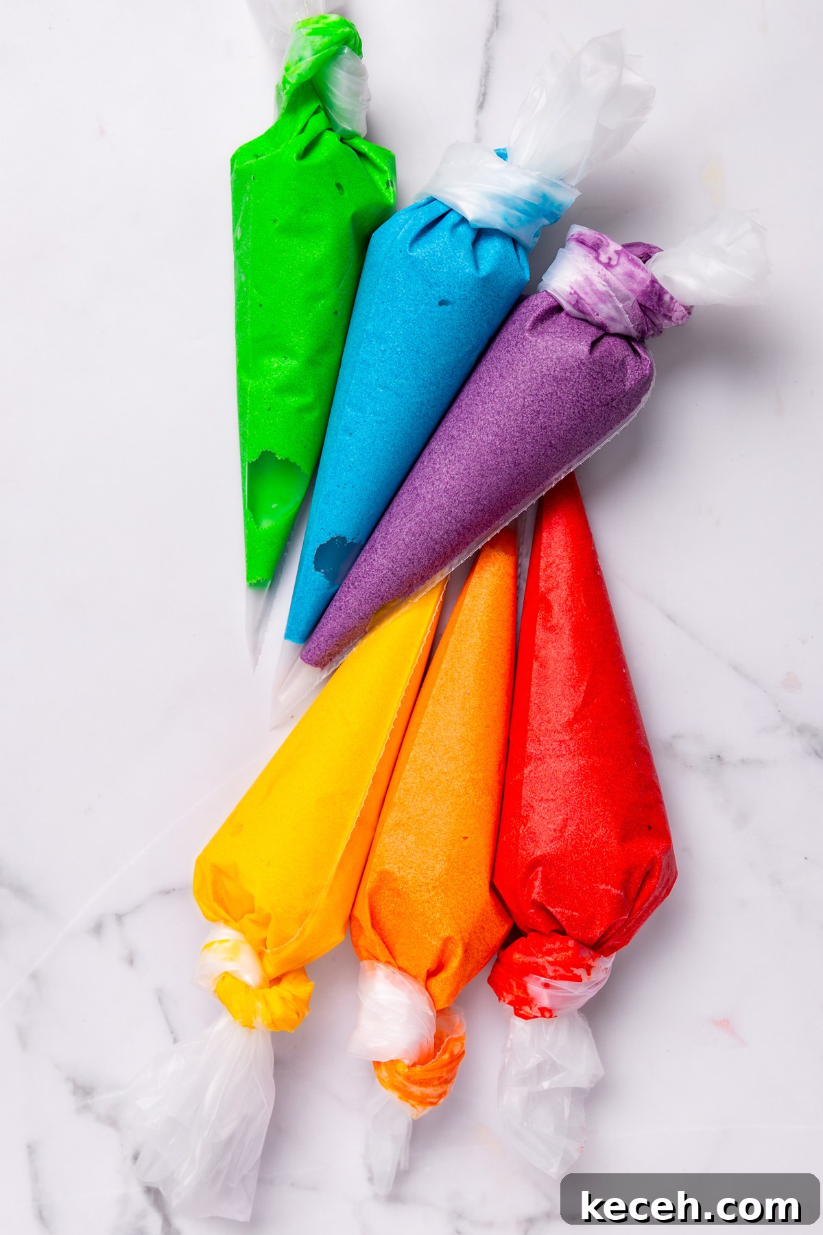 How to Make Colorful Rainbow Cupcakes at Home 7 piping bags filled with colorful cupcake batter for rainbow cupcakes