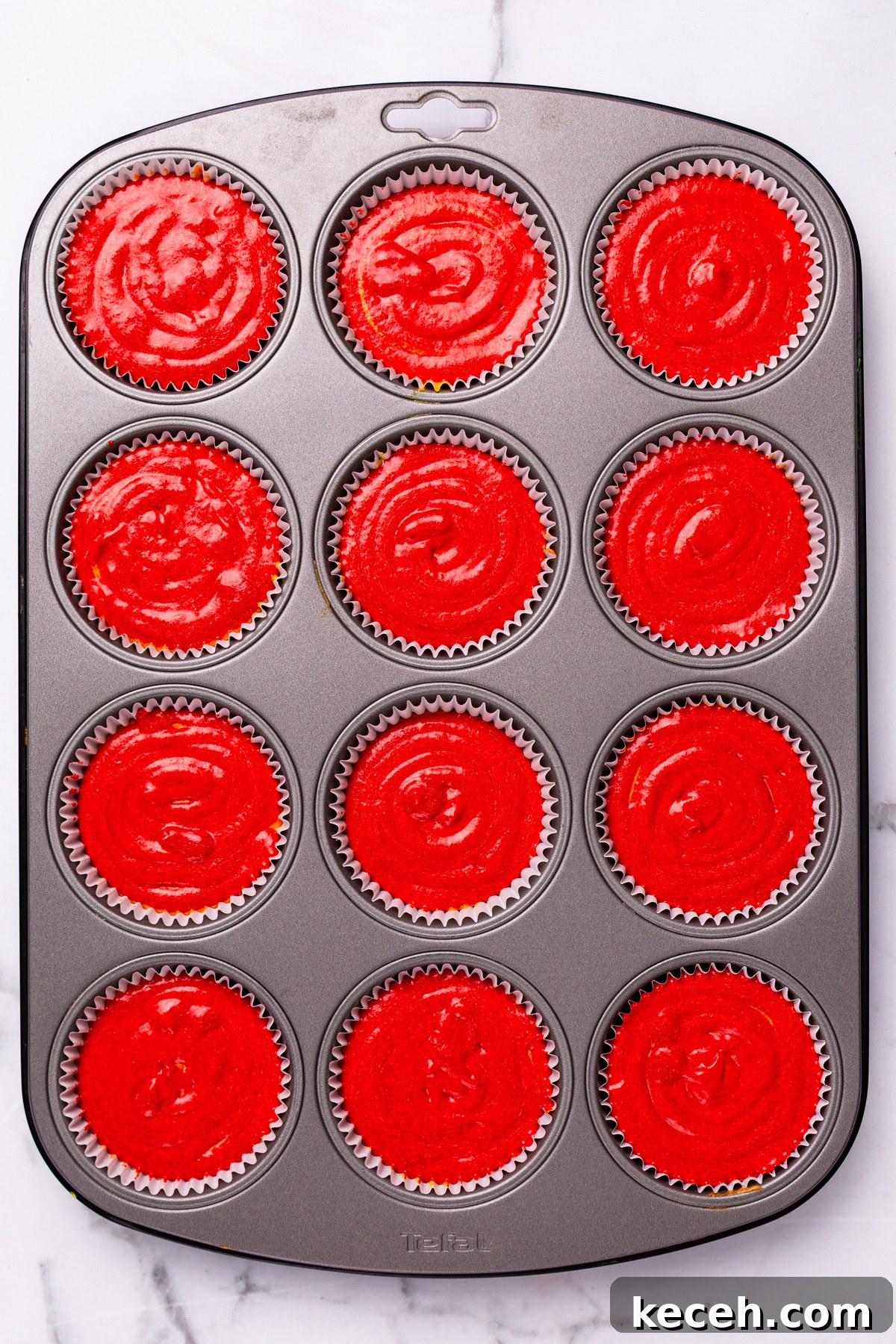 How to Make Colorful Rainbow Cupcakes at Home 8 muffin tin filled with rainbow cupcakes batter before baking