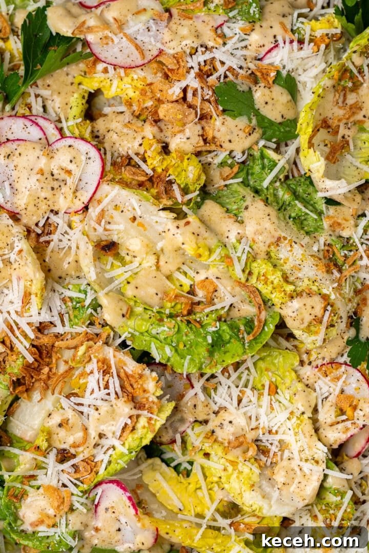 close up of little gem salad with Caesar vinaigrette, parmesan, radishes, and crispy shallots