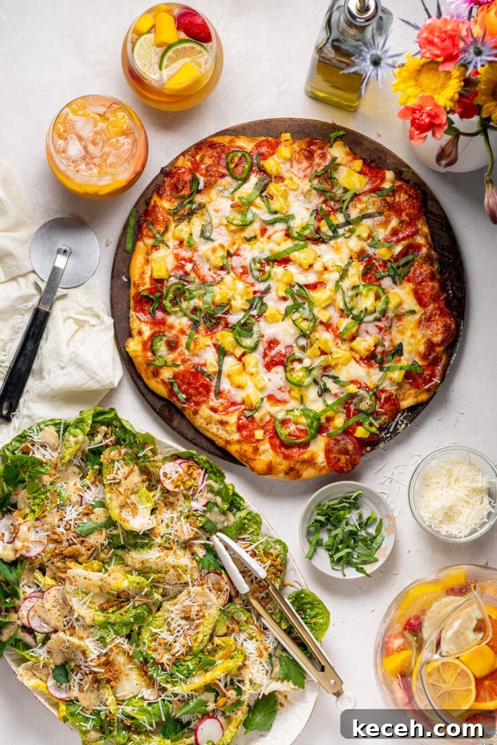 salad recipe with Caesar vinaigrette served with pepperoni pineapple pizza and citrus drinks