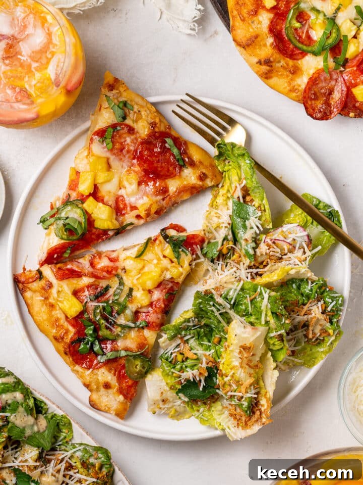 pepperoni pineapple pizza slices served with Caesar salad with parmesan cheese and crispy shallots
