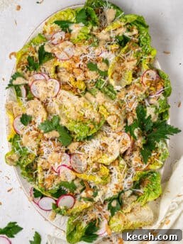 little gem salad recipe with Caesar vinaigrette, parmesan cheese, pistachios, and crispy shallots on platter