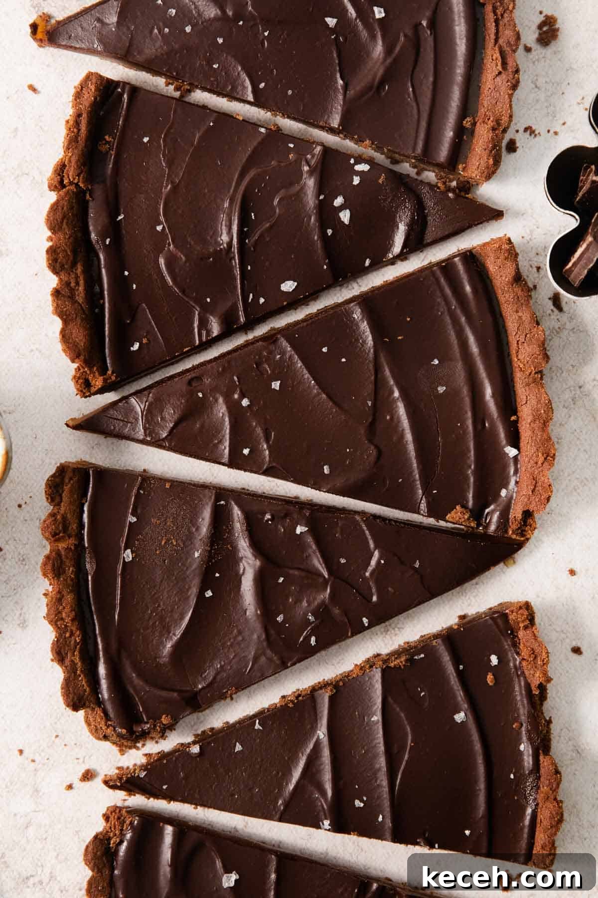 Decadent Gluten-Free Chocolate Caramel Tart Recipe 6 slices of gluten-free chocolate caramel tart lined up in a row on a countertop