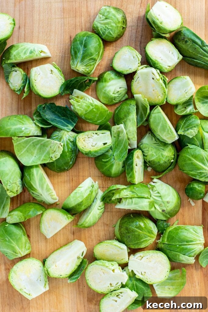 Crispy Roasted Brussels Sprouts with Bacon and Balsamic Glaze 4 Trimmed and halved Brussels sprouts on a cutting board.