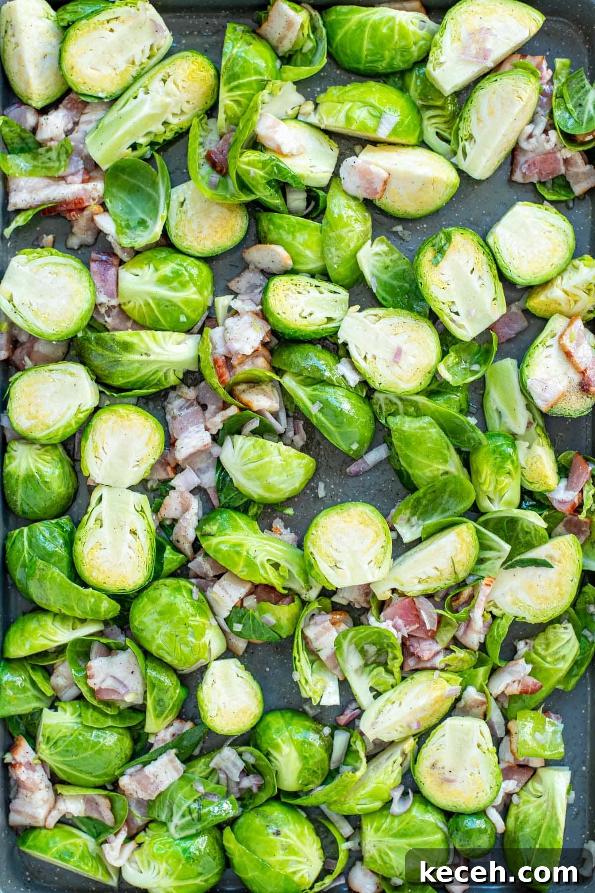 Crispy Roasted Brussels Sprouts with Bacon and Balsamic Glaze 7 Uncooked Brussels sprouts, chopped shallots, and chopped bacon laid out on a baking sheet.
