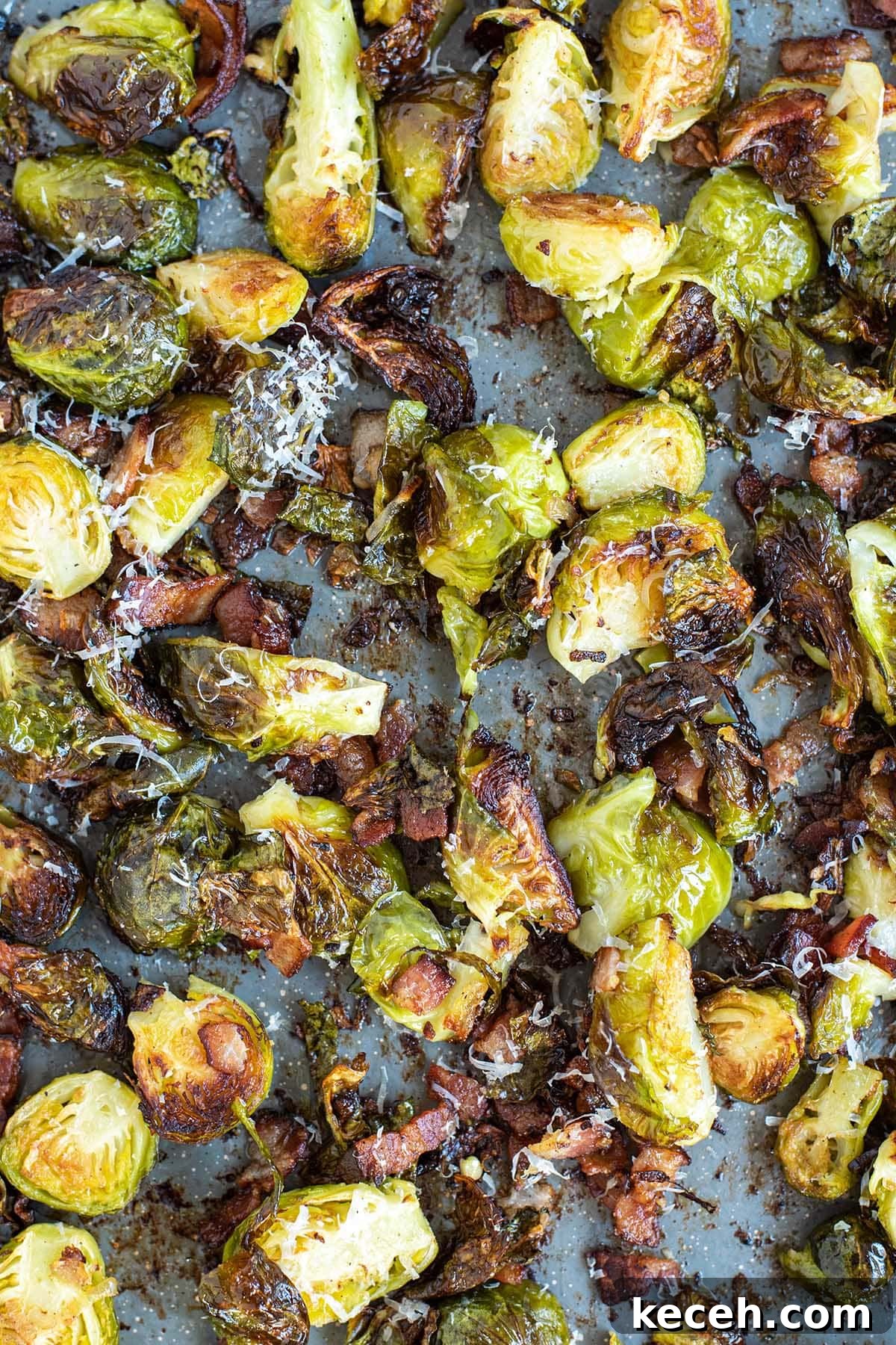 Crispy Roasted Brussels Sprouts with Bacon and Balsamic Glaze 8 Crispy golden brussels sprouts topped with fresh grated parmesan cheese on a baking sheet.