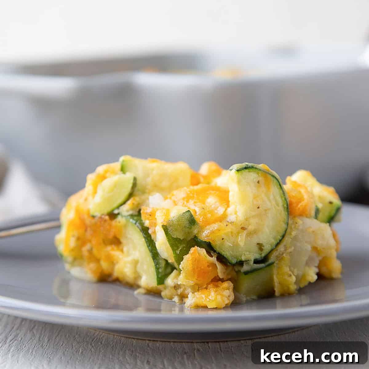 slice of old fashioned zucchini casserole on a gray plate.