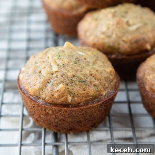 zucchini muffins with coconut and walnuts on a wire rack.
