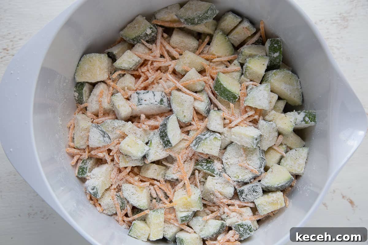 bowl of chopped zucchini and shredded cheddar coated in bisquick.