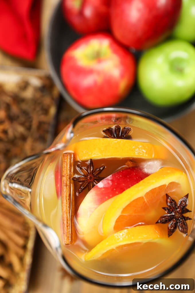 Autumn Apple Cider Sangria with Bourbon Twist 4 A pitcher of apple cider sangria with slices of apples and oranges with three star anise.