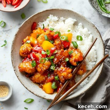 Family Meal Plan: Budget-Friendly Weekly Menu (Plan 138) 6 Easy sweet and sour chicken with peppers and pineapple on a white plate.