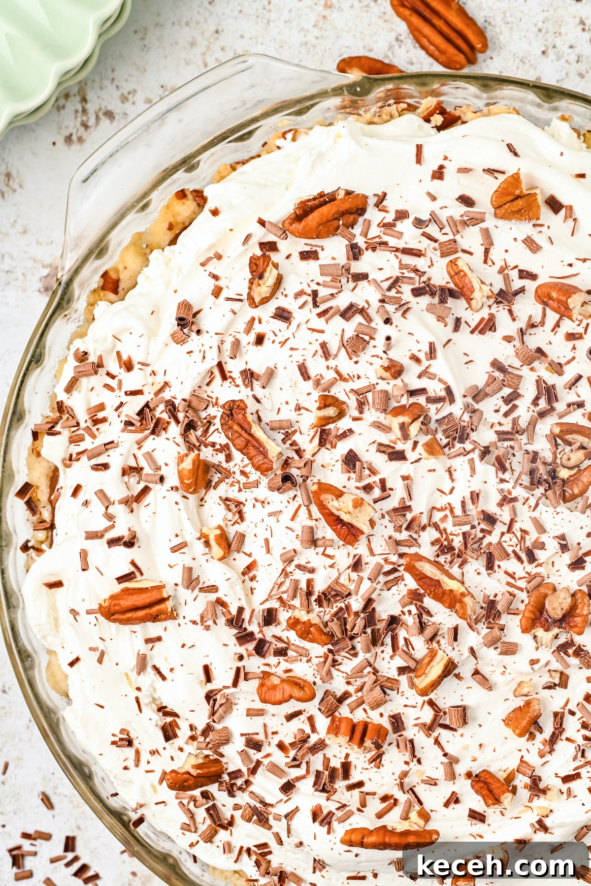 Southern Possum Pie Recipe: Classic Layered Chocolate Pudding Pie 2 A glass pie dish filled with a possom pie that's topped with cool whip and roughly chopped pecans.