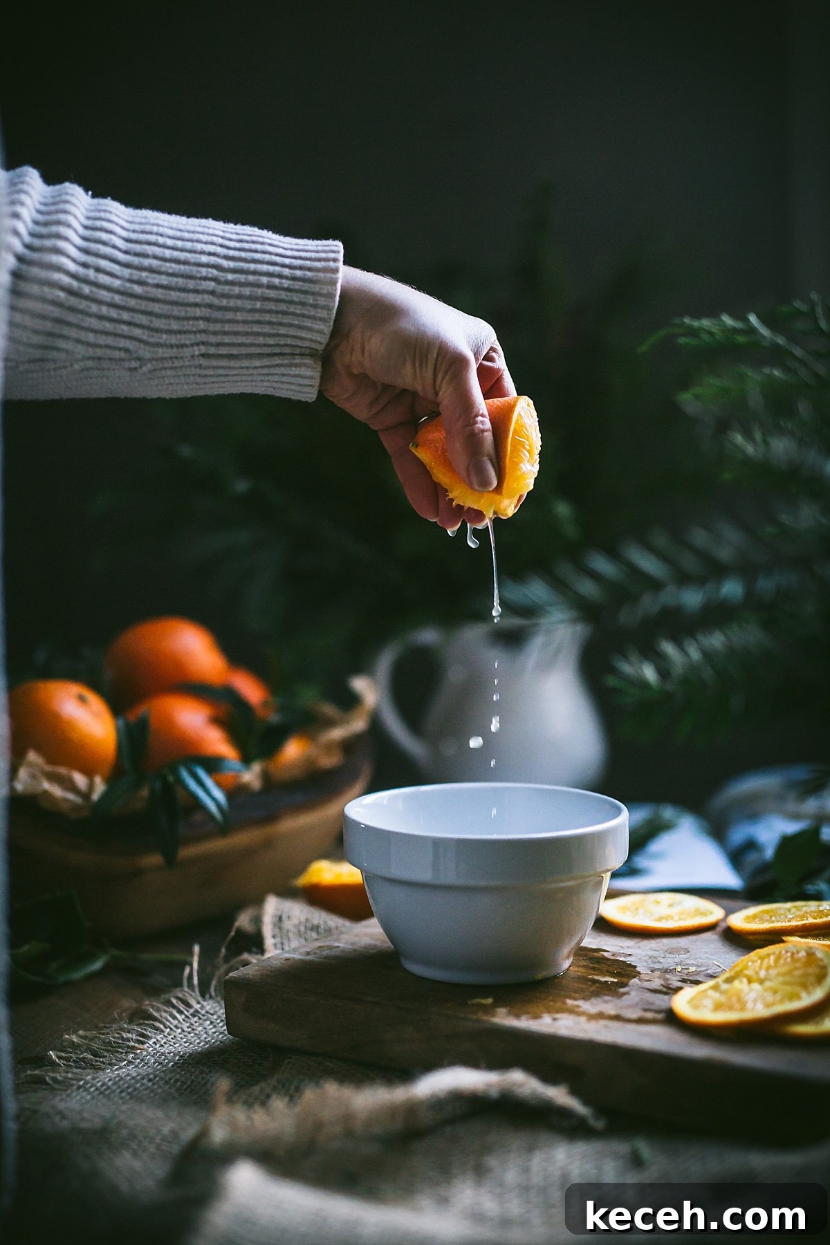 Vasilopita (Greek New Year Cake) — Slow Cooker or Oven Recipe 6 A hand squeezing orange juice into a small white bowl for Vasilopita.