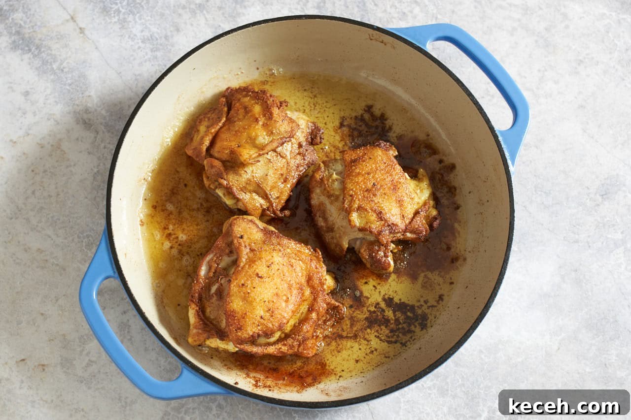 Skillet Chicken Tagine with Apricots and Warm Spices 6 Cooked chicken thighs with crispy skin in a skillet.
