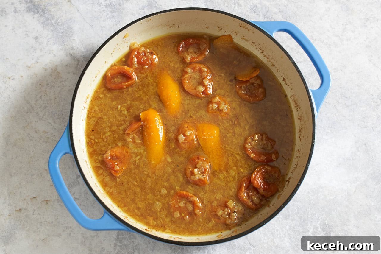 Skillet Chicken Tagine with Apricots and Warm Spices 7 Broth, orange peels, and apricots in a skillet.