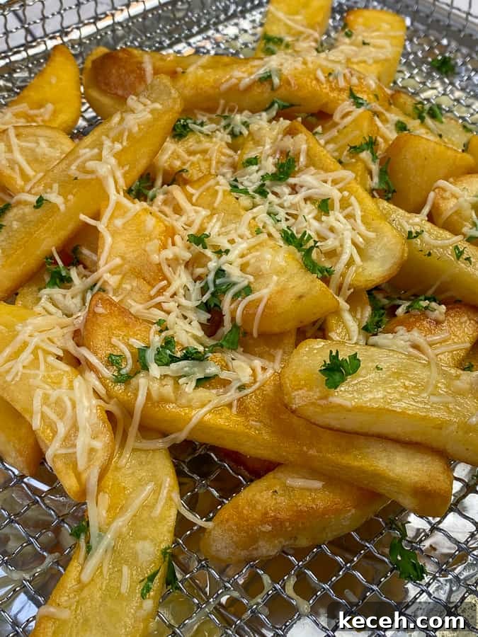 Loaded garlic parmesan fries in air fryer tray are homemade version of Red Robin's recipe