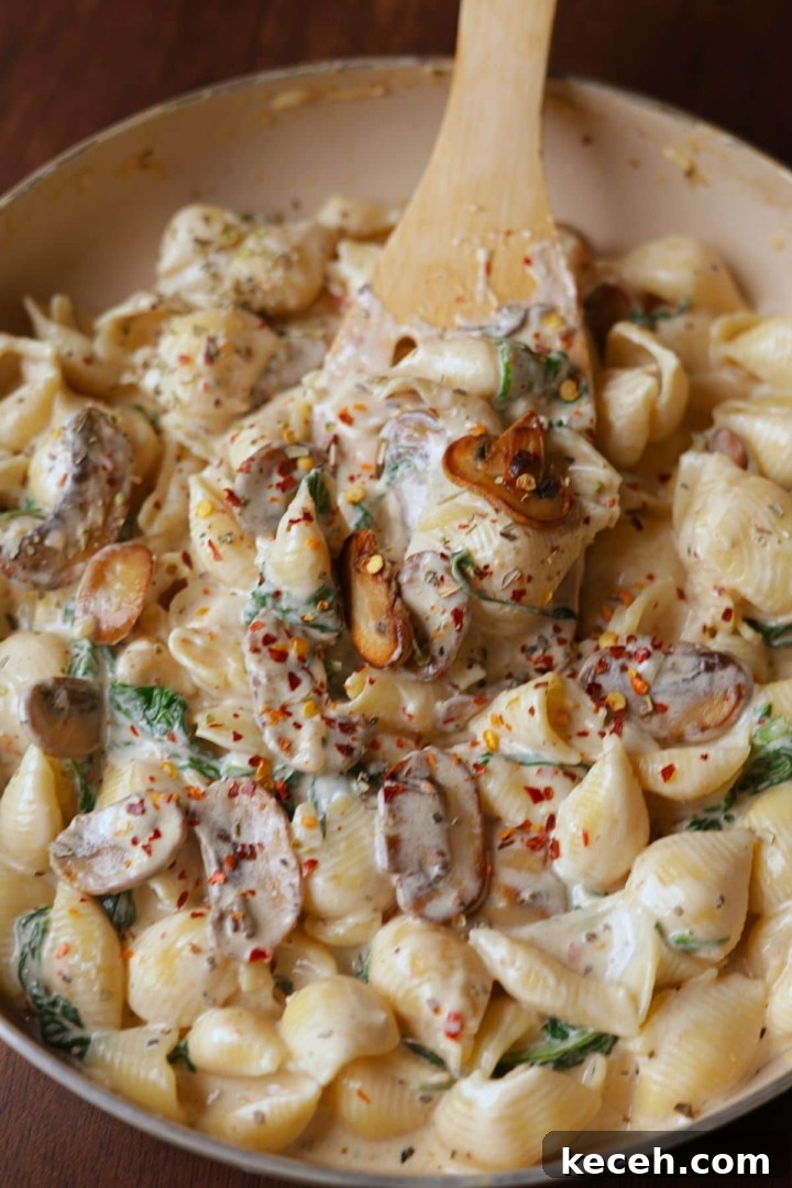 Creamy Mushroom & Spinach Pasta Recipe for Weeknight Dinners 2 Creamy spinach and mushroom pasta in a off white pan.