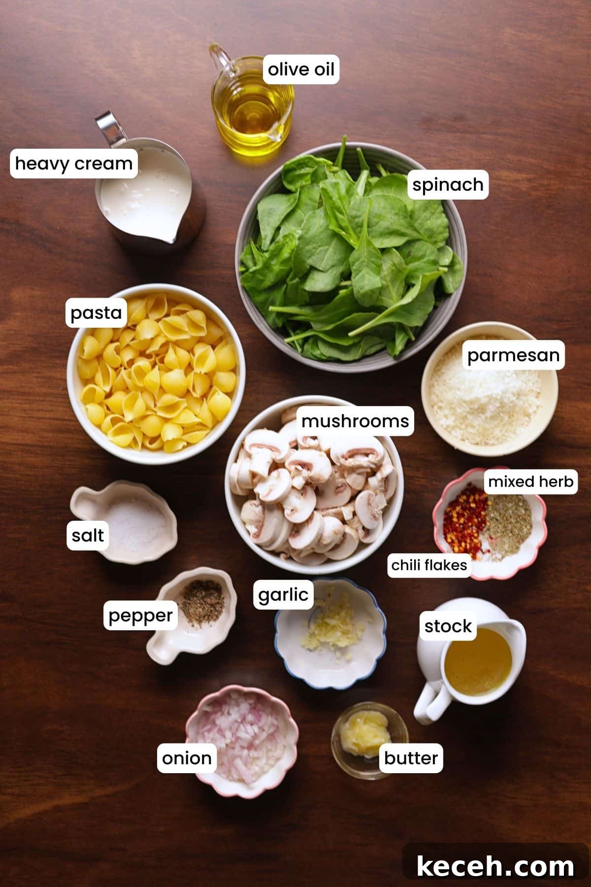 Creamy Mushroom & Spinach Pasta Recipe for Weeknight Dinners 3 All ingredients of spinach mushroom pasta arranged on a wooden background.