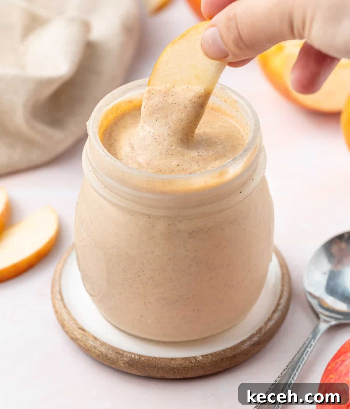 Apple Curd Recipe: Smooth Homemade Apple Spread 5 Dipping a slice of apple in the curd jar.