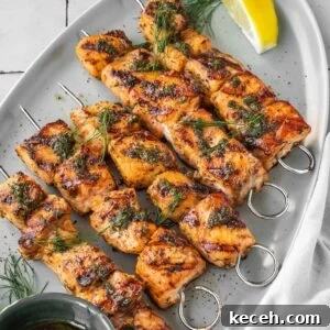Grilled Mediterranean Salmon Kabobs on a platter garnished with dill and a side of lemon wedges.