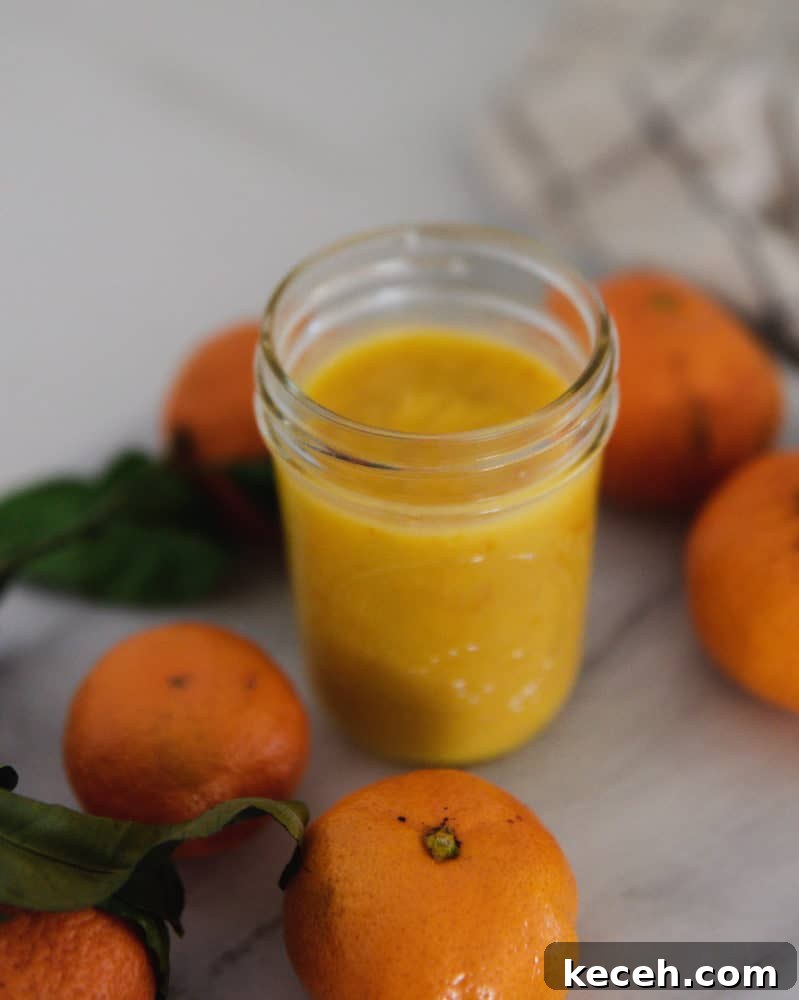 No-Fail Orange Curd Recipe — Smooth, Tangy, Homemade 2 Jar of orange curd on countertop with mandarin oranges.