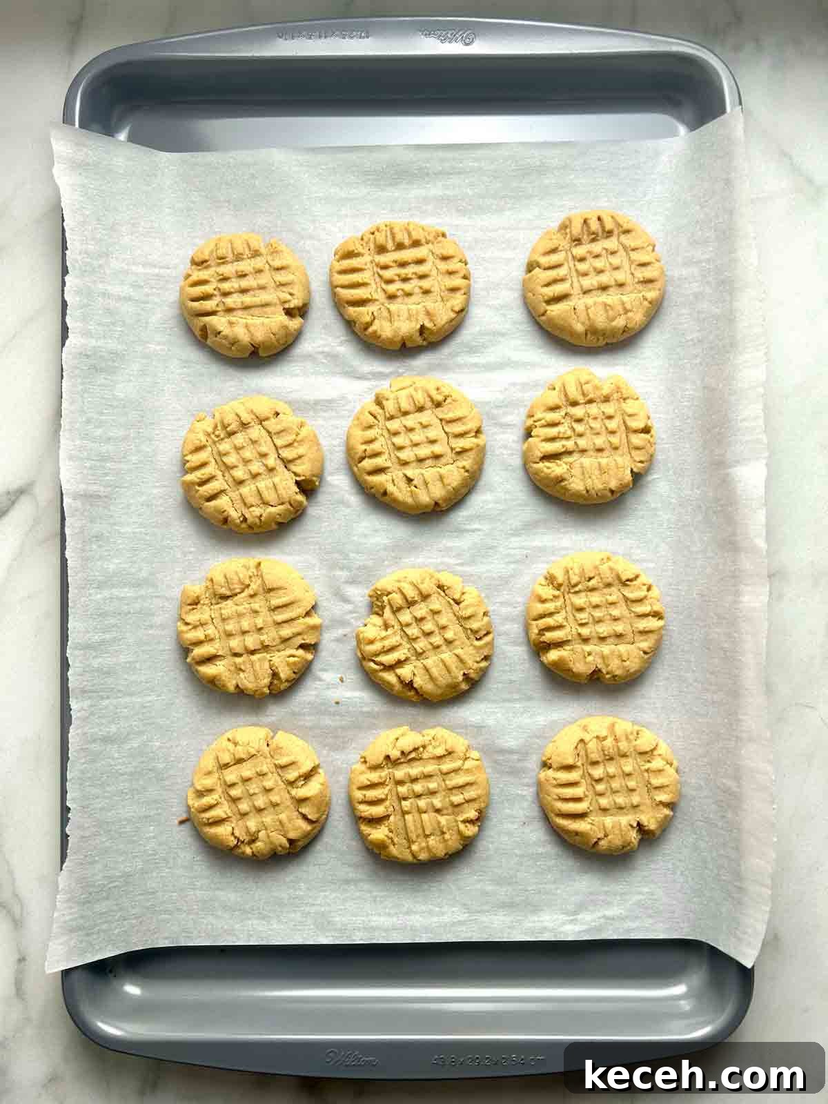 Chewy Peanut Butter Cookies Recipe with Crispy Edges 8 peanut butter cookies on baking sheet after baking for 10 minutes.