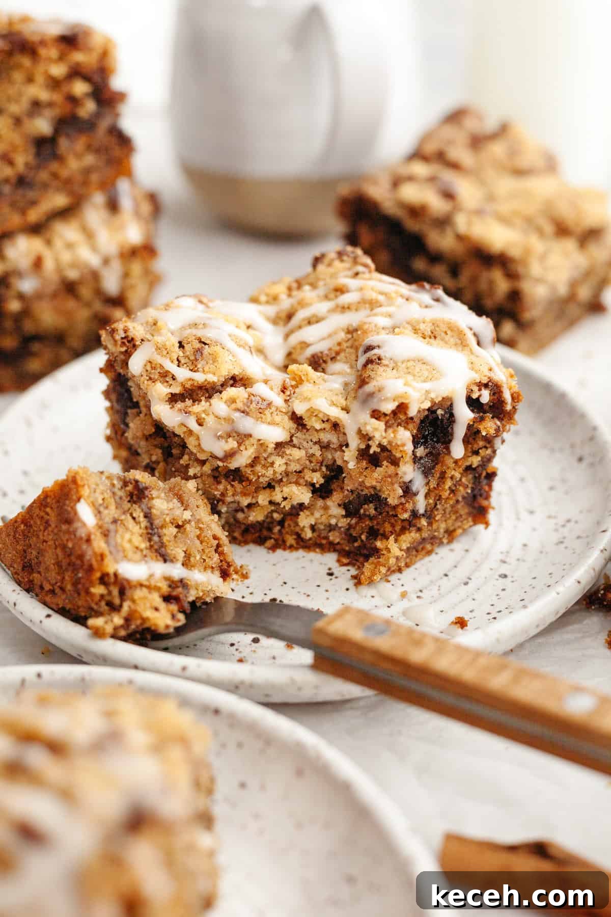 Moist Banana Coffee Cake with Sour Cream Glaze 11 A slice of banana bread coffee cake drizzled with a white glaze on a small plate.